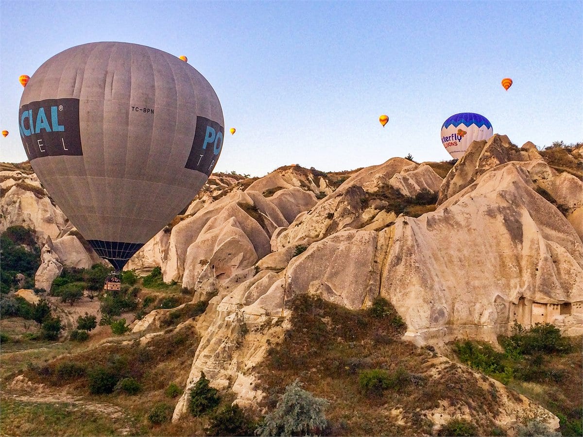 Balloons drifting low over the fairy chimneys in the first light of morning